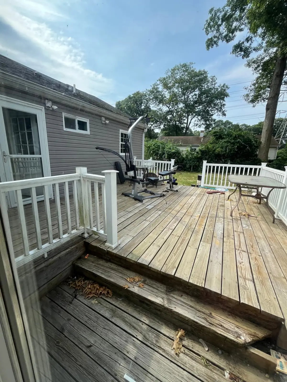 Selling a house with foundation problems in Ronkonkoma: back deck with rotted, collapsed boards at the steps