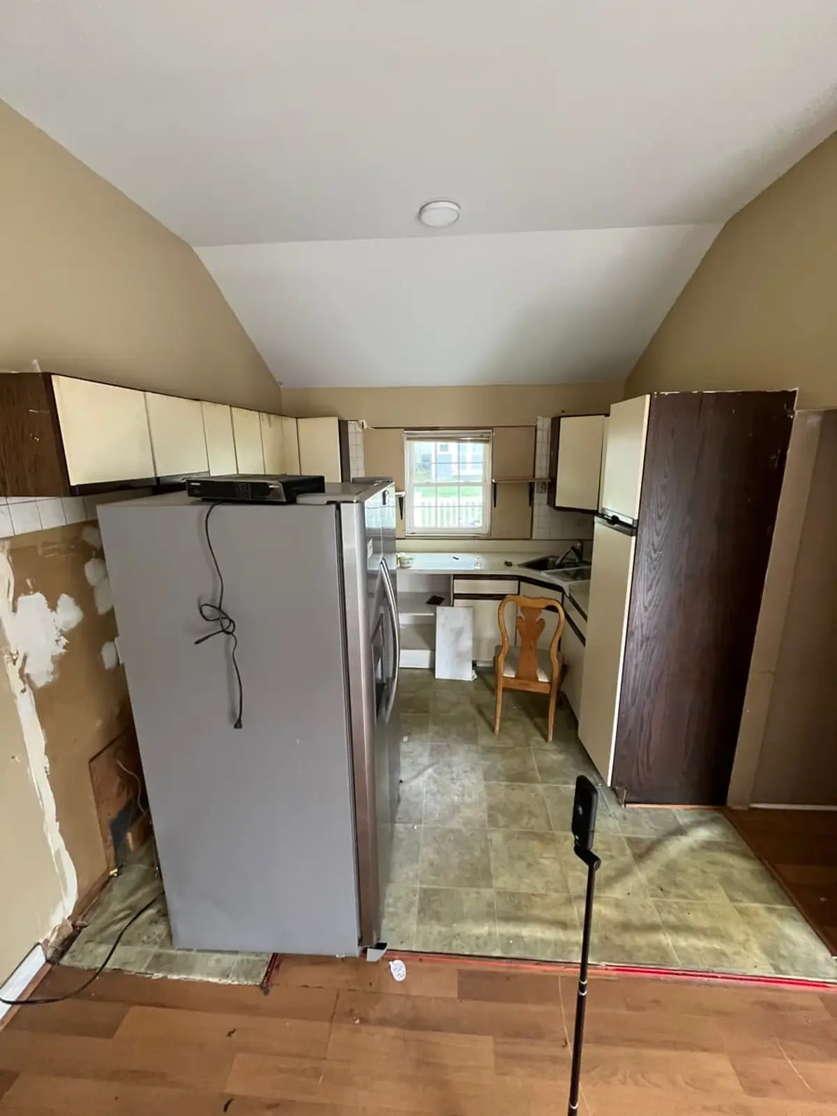 Wondering what your Ronkonkoma house is worth: kitchen with the fridge pulled out and patched, damaged walls
