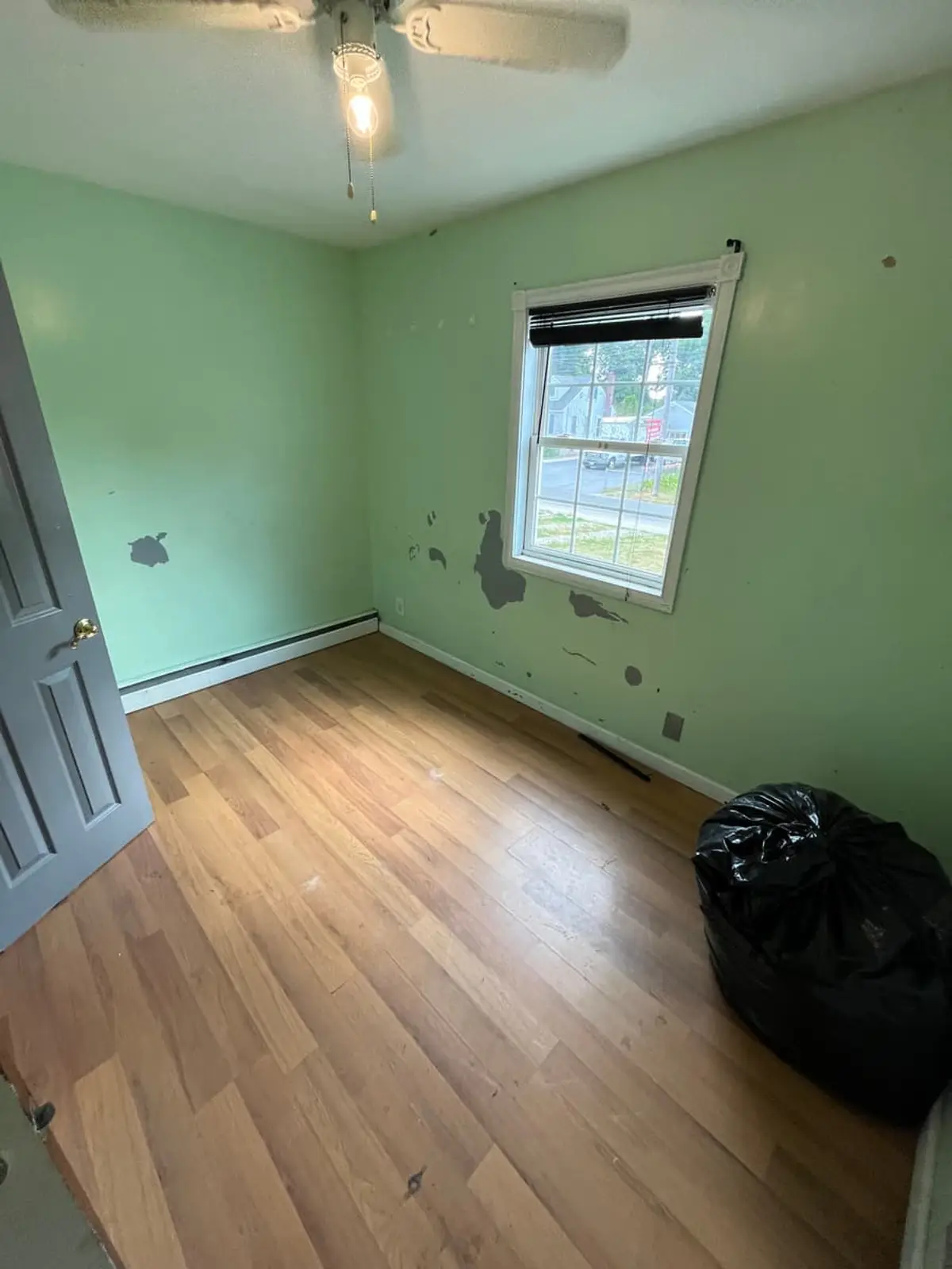 Selling a house near the LIRR in Ronkonkoma: mint-green bedroom with spackle patches on the walls
