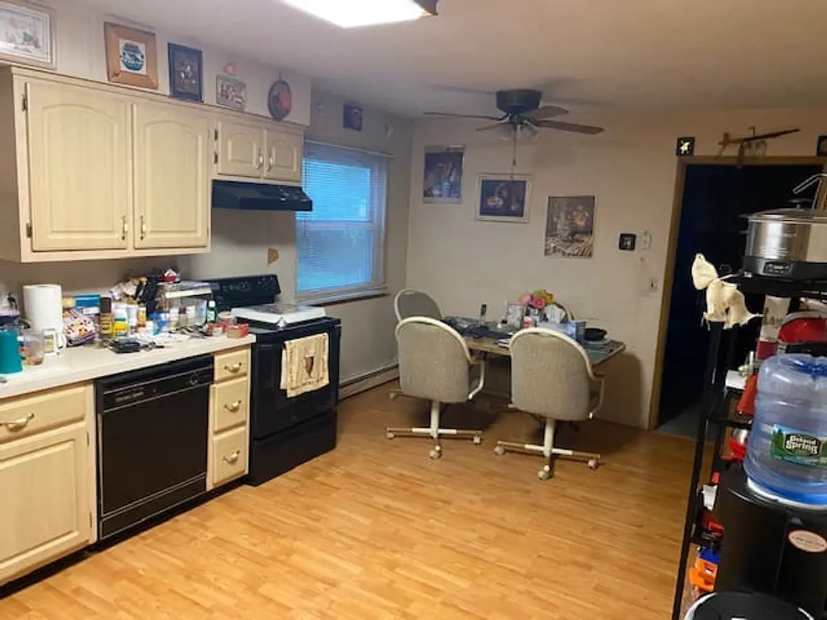 Downsizing or retiring in Ronkonkoma: occupied kitchen with cream cabinets and a dinette set