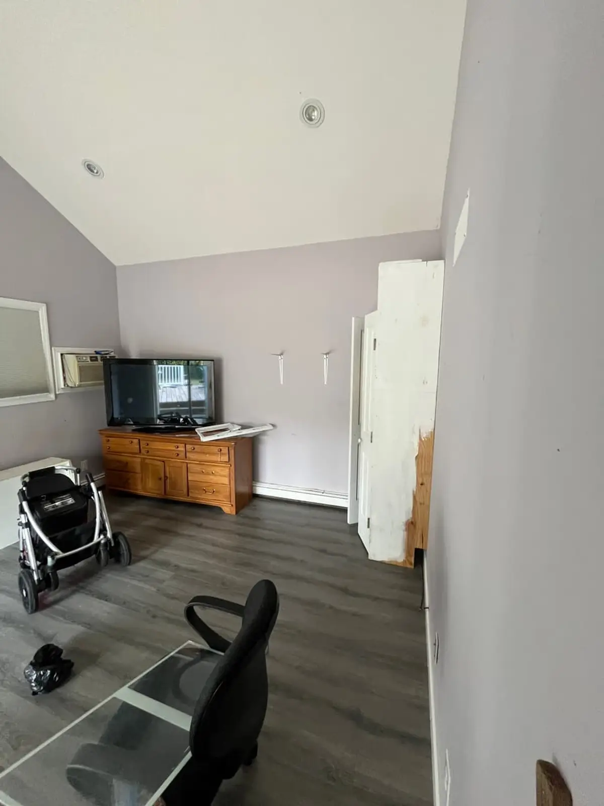 Selling a house during a divorce in Ronkonkoma: occupied living room with a vaulted ceiling and gray plank floor