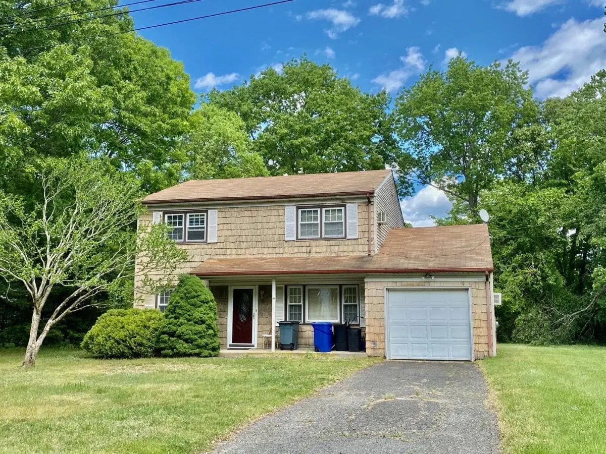 Selling a multi-family house in Ronkonkoma: shingled colonial with an attached garage and a wide front lawn