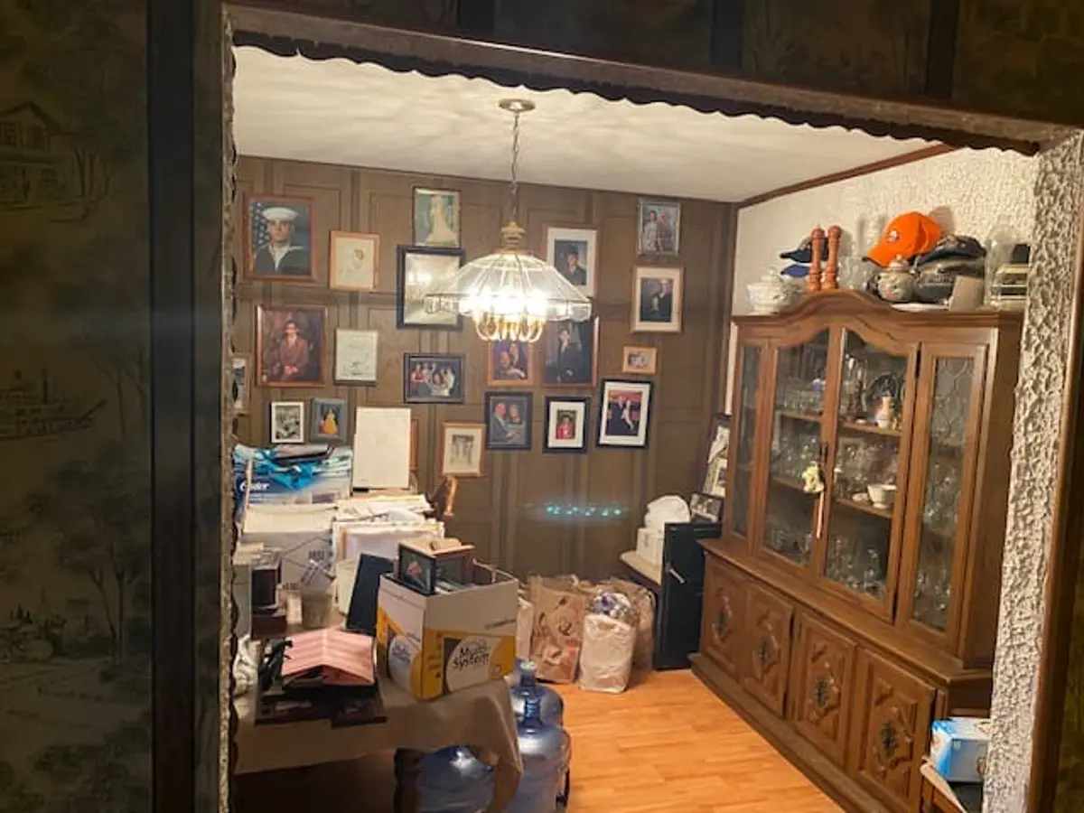 Selling a house with a reverse mortgage in Ronkonkoma: wood-paneled dining room with a china cabinet and crowded table